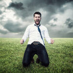 Podnikateľ plánuje v zápisníku pri stole s notebookom a kávou.