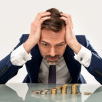 Živnostník počíta odvody a dane na notebooku pri práci v kancelárii.