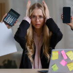 Účtovník pracuje s mzdovými dokumentmi a finančnými údajmi na počítači