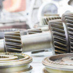 Priemyselný elektromotor a prevodovka vo výrobnej hale počas prevádzky