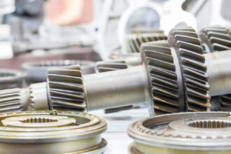 Priemyselný elektromotor a prevodovka vo výrobnej hale počas prevádzky