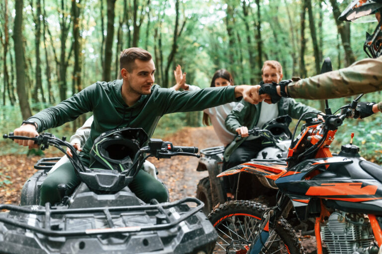 Úžitková terénna štvorkolka ATV s nákladným prívesom pri pracovnom využití na farme.
